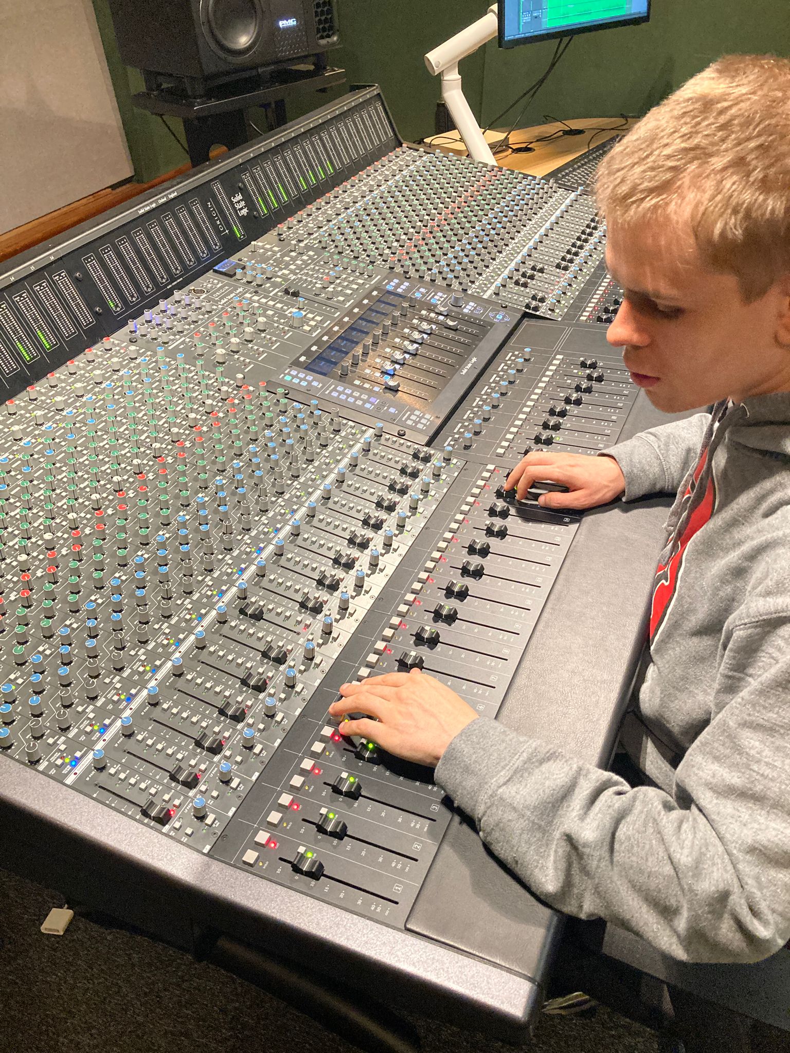 Marshall exploring the operation of a large professional mixer, in the progress of adjusting a volume slider.