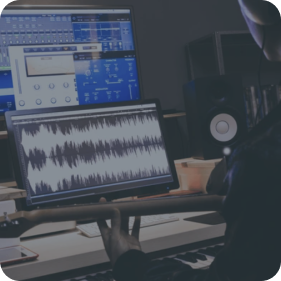 A musician holding a guitar in a modern music production studio, with a digital audio workstation on the screen displaying waveforms and various audio processing plugins.